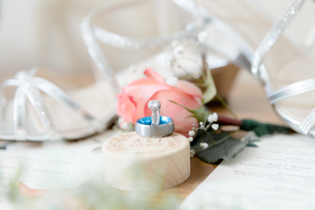 Detail shot of the wedding rings and flowers at the Outpost Center in Chaska