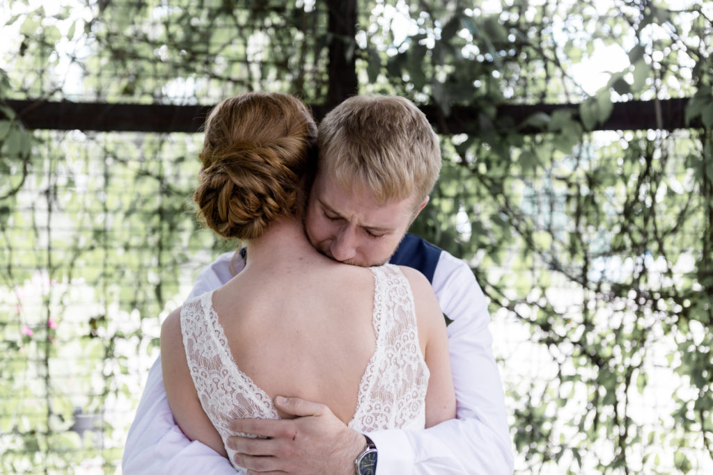 Bride and Groom hug each other during their First Look at the Outpost Center in Chaska