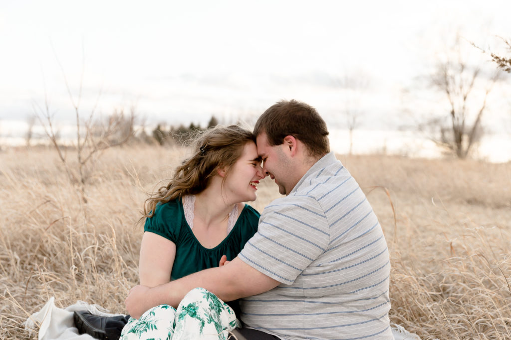 a couple laugh with each other during engagement session